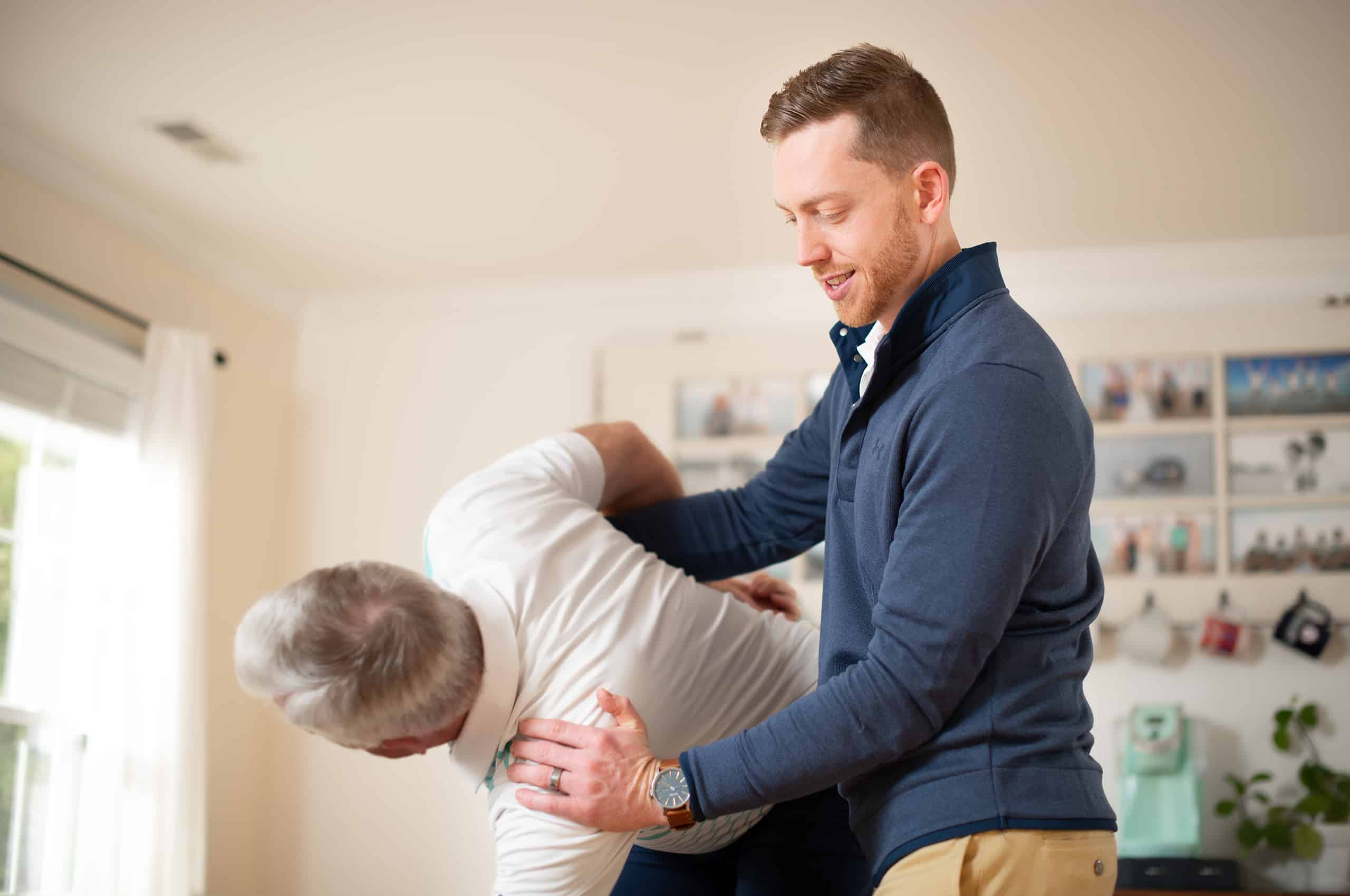 Physical therapist working on older mans back and shoulders