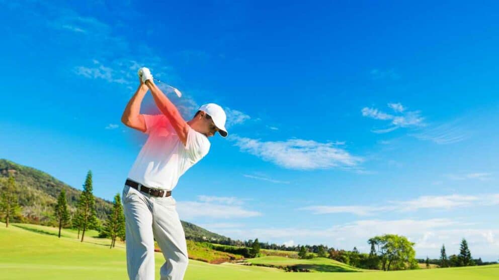 Golfer swinging, white polo shirt and white pants.